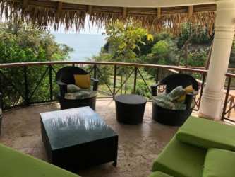 Outdoor dining area under palapa with ocean view in Costa Esmeralda Panama