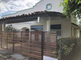Front exterior with tiled roof white facade gate and garden Costa Esmeralda Panama