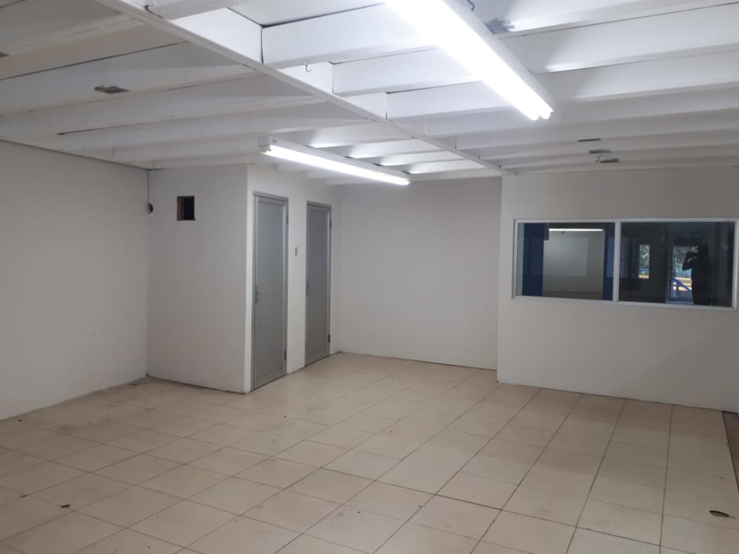 Empty finished office area with tile floor and fluorescent lighting inside warehouse Panama City