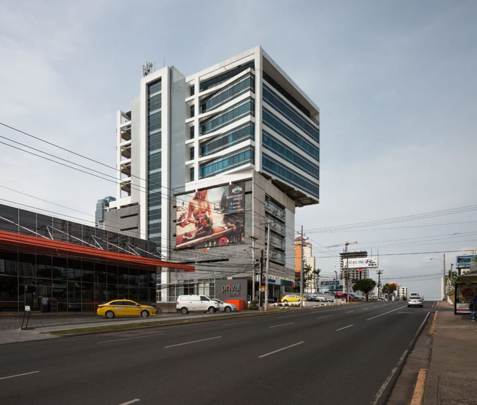 Glass facade multi-story office tower with billboards along Calle 50 Panama City Panama