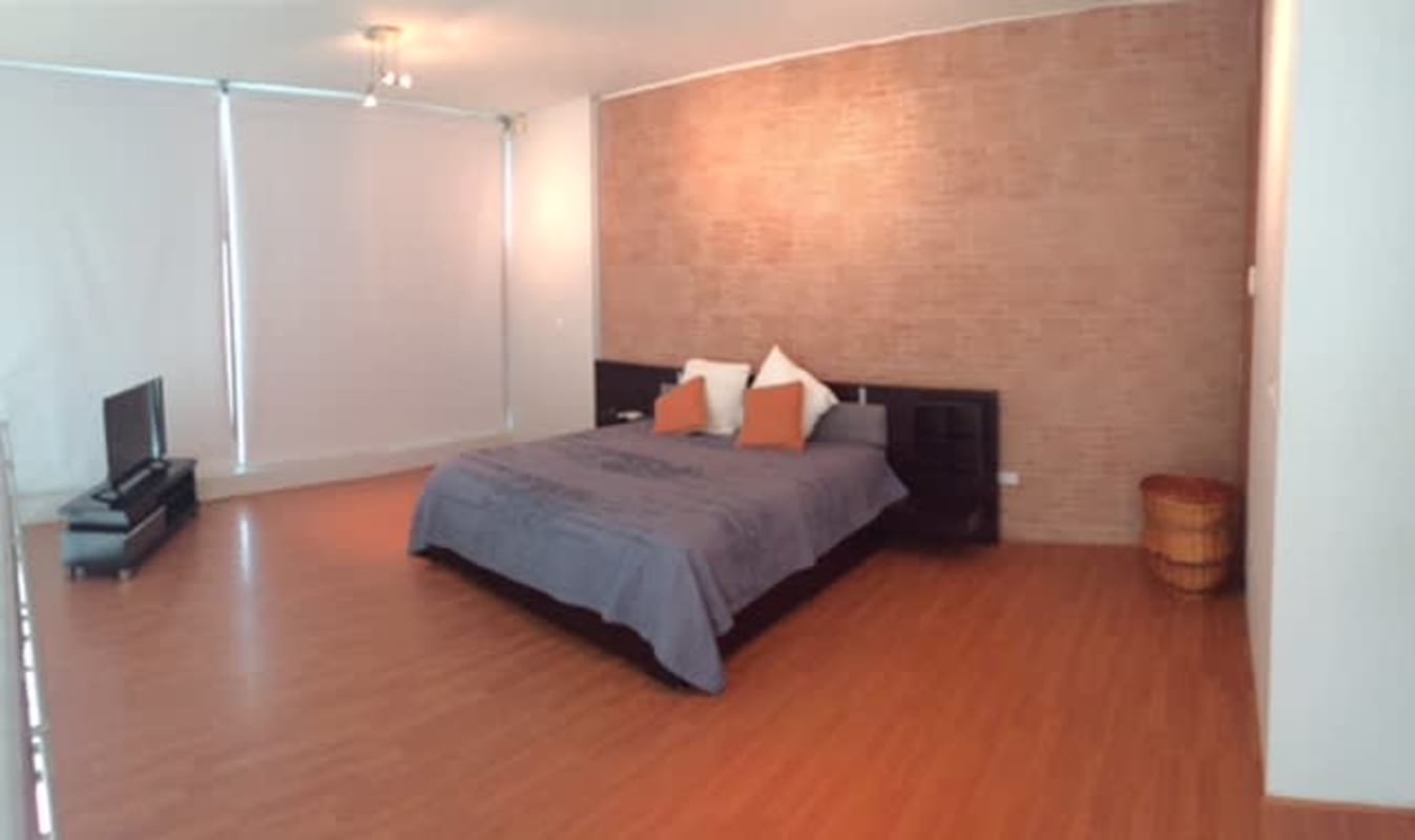 Large loft-style bedroom with wood floor exposed brick wall PH Loft 41 Panama