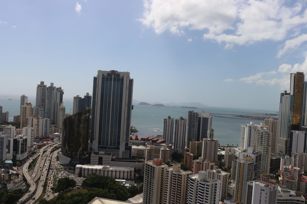 Aerial cityscape of coastal Panama City skyline with high-rise towers and ocean