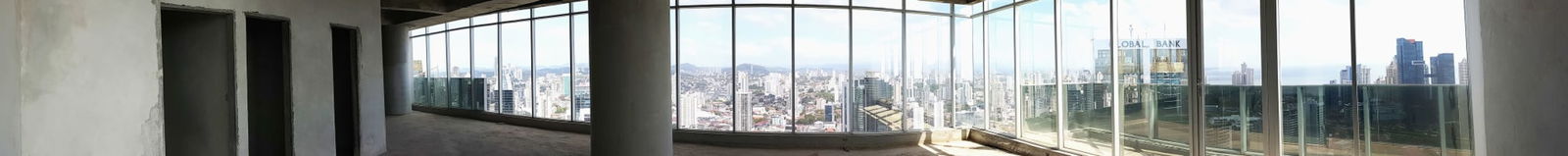 Unfinished high-rise office interior with floor-to-ceiling panoramic windows and skyline view