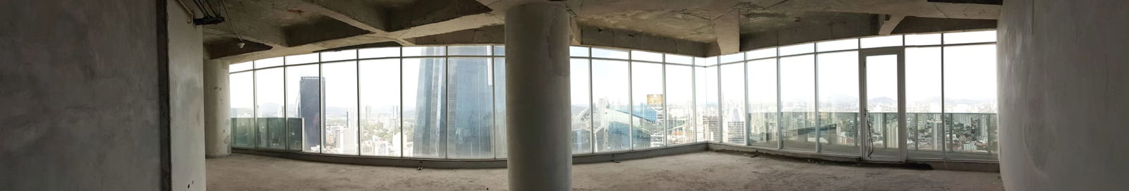 Raw unfinished commercial office space with panoramic city views in high-rise