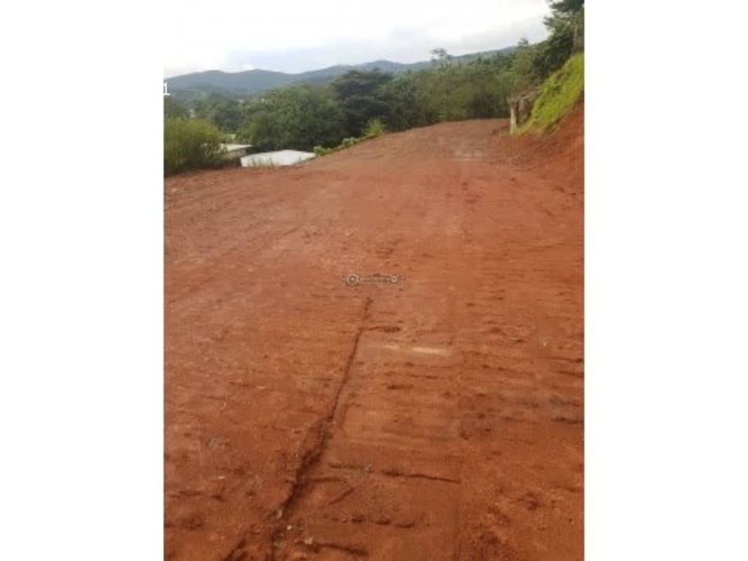Fenced undeveloped slope land plot with red clay soil and mountain views in Altos de Tocumen Panama City