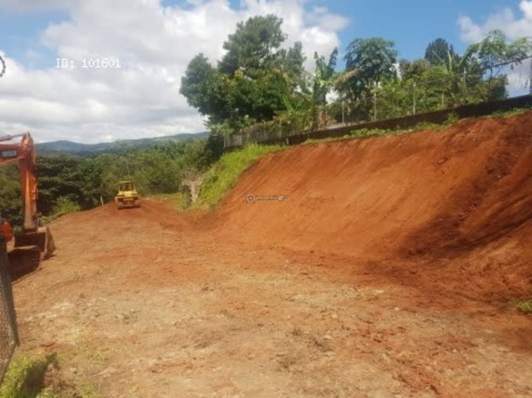 Excavation in process on sloped red clay soil lot for future development in Altos de Tocumen Panama