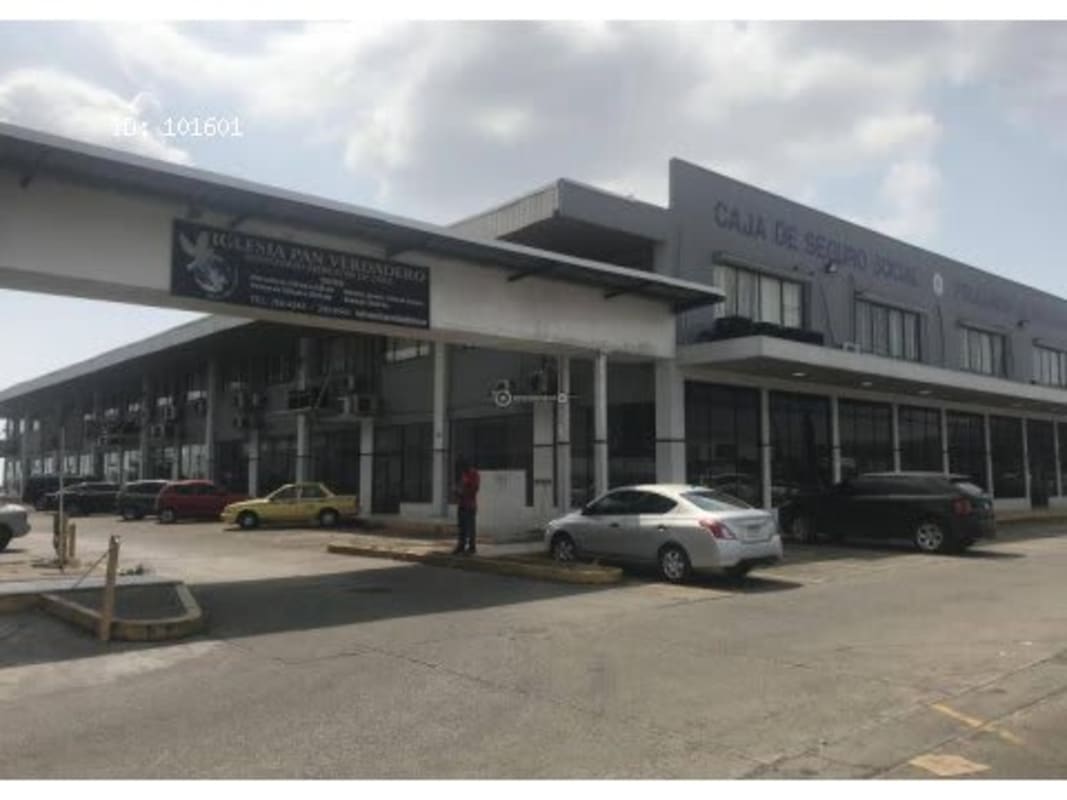 Urban street with commercial signage and traffic outside Plaza El Cruce Pedregal