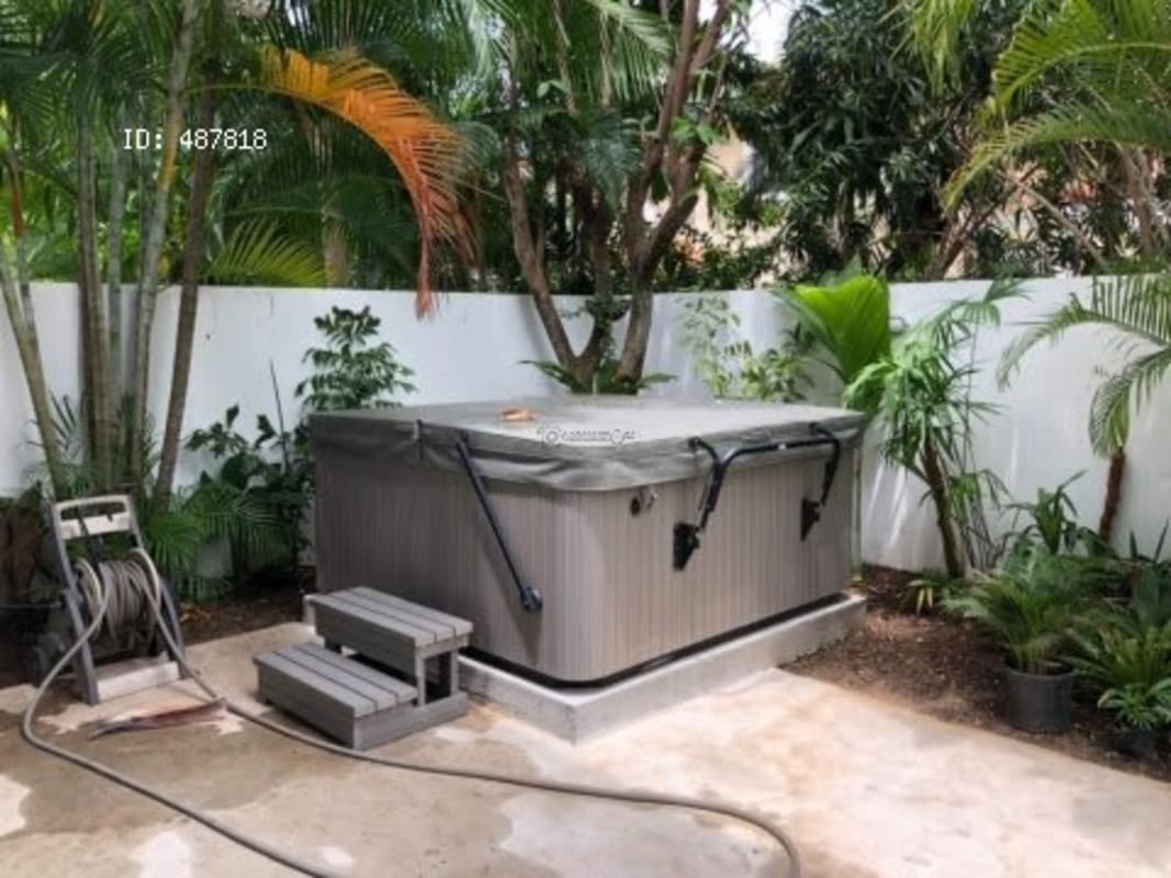 Outdoor patio with covered jacuzzi spa surrounded by tropical landscaping in Costa Serena