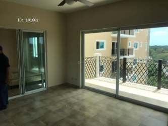 Modern condo living area sliding doors open to balcony with views of swimming pool and garden in PH Alcazar Coronado Panama