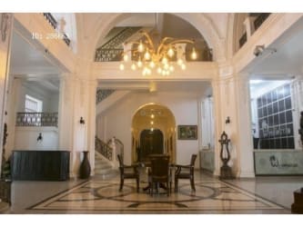 Grand staircase with columns and chandelier inside Hotel Washington Colon Panama historic property
