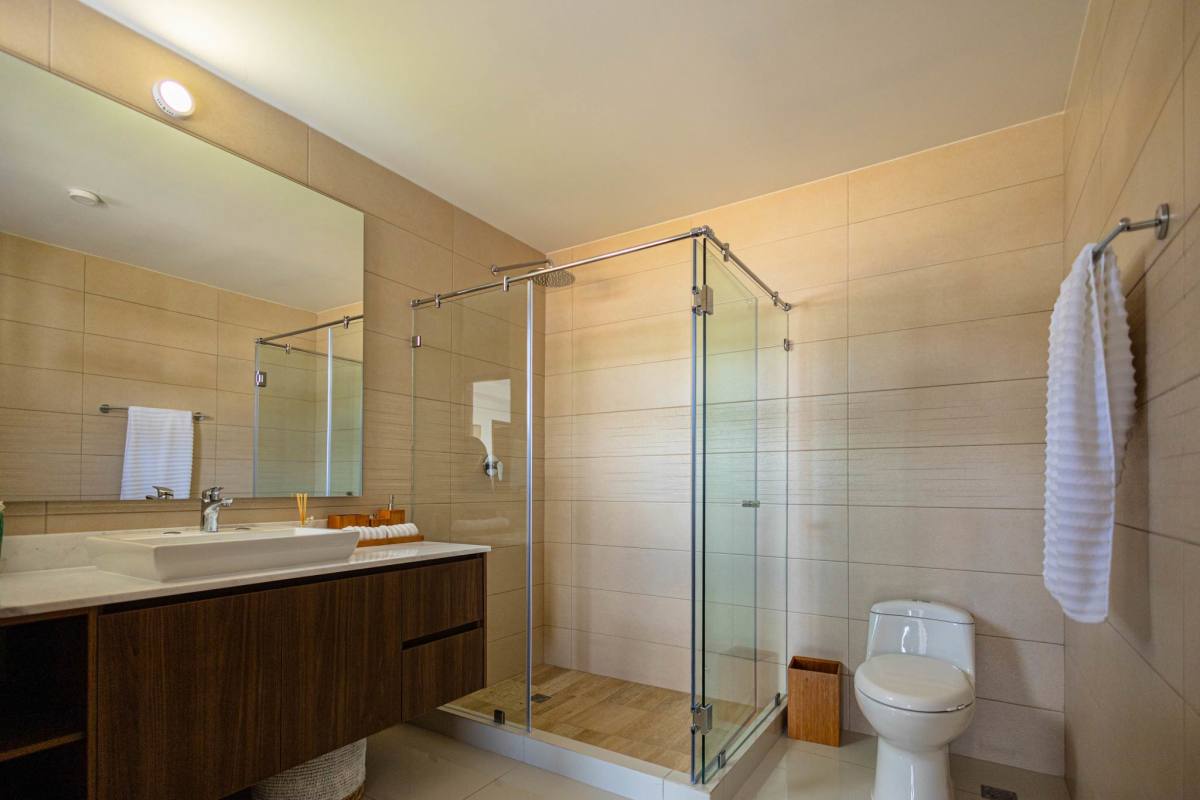 Bathroom featuring glass-enclosed shower, floating vanity, large mirror and tile walls in Arcadia Costa Verde