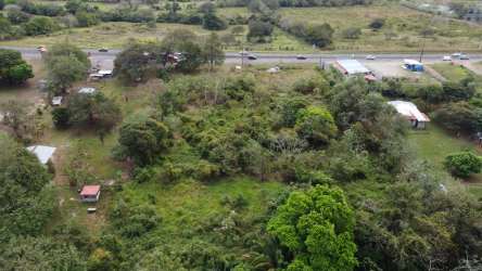 Undeveloped grassy hill lot bordering Inter-American Highway with billboard frame Capira Panama