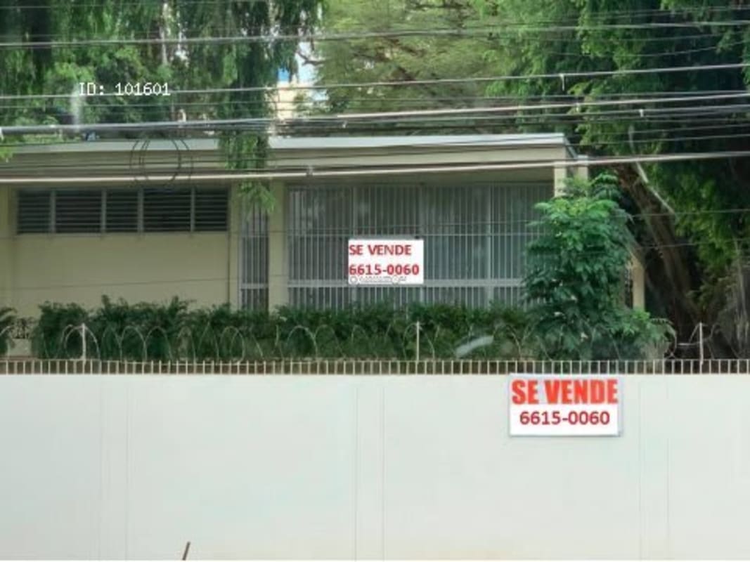 Tall wall with barbed wire security around corner investment lot in Obarrio Panama