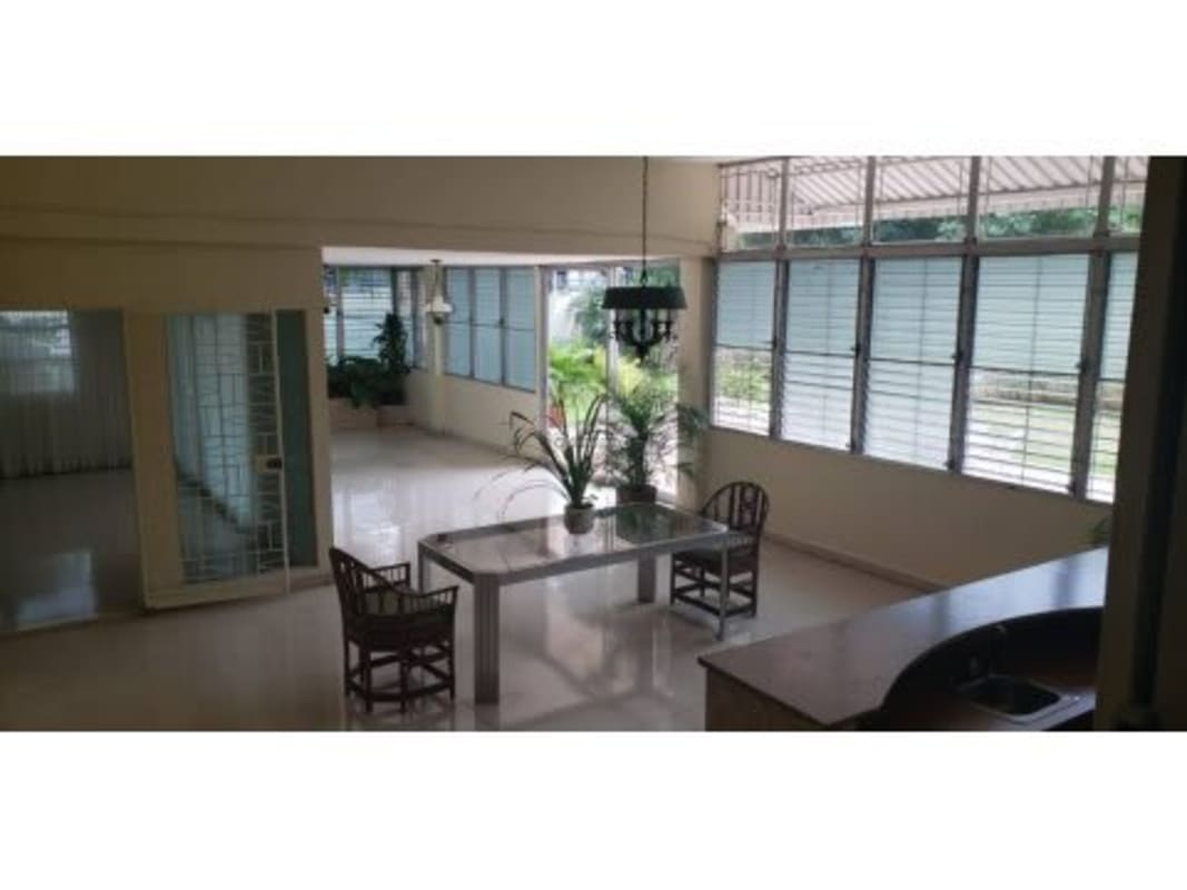 Dining room with glass table large windows greenery view in Obarrio House Panama City