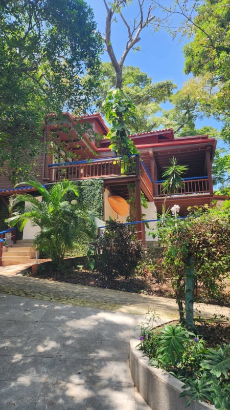 Wooden beach house with balconies surrounded by lush trees on Isla Saboga, Panama