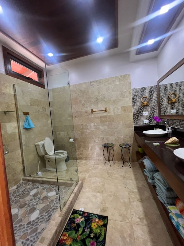 Spacious bathroom with glass shower, dual sinks, modern design in beach villa Saboga Island