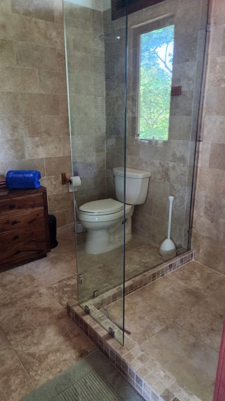 Contemporary bathroom with glass enclosure and garden view Isla Saboga beachfront villa Panama