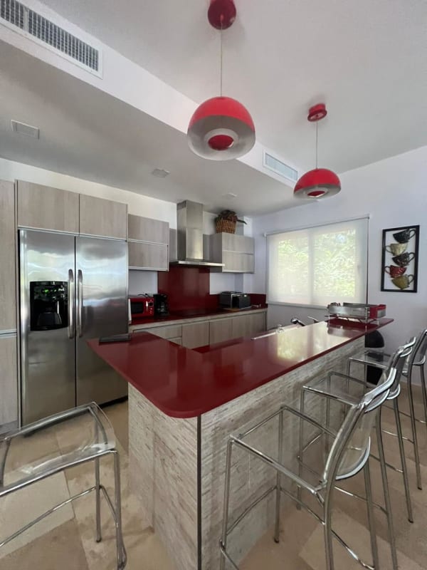 Contemporary kitchen with red quartz counters and modern appliances in Saboga beachfront home