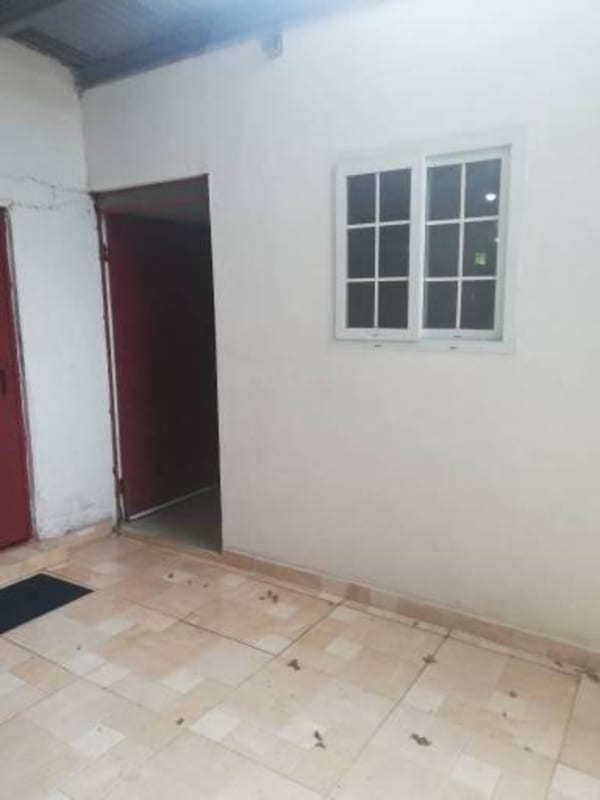 Small L-shaped kitchen with burgundy cabinets, white countertops, window in studio apartment for rent La Loma Panama