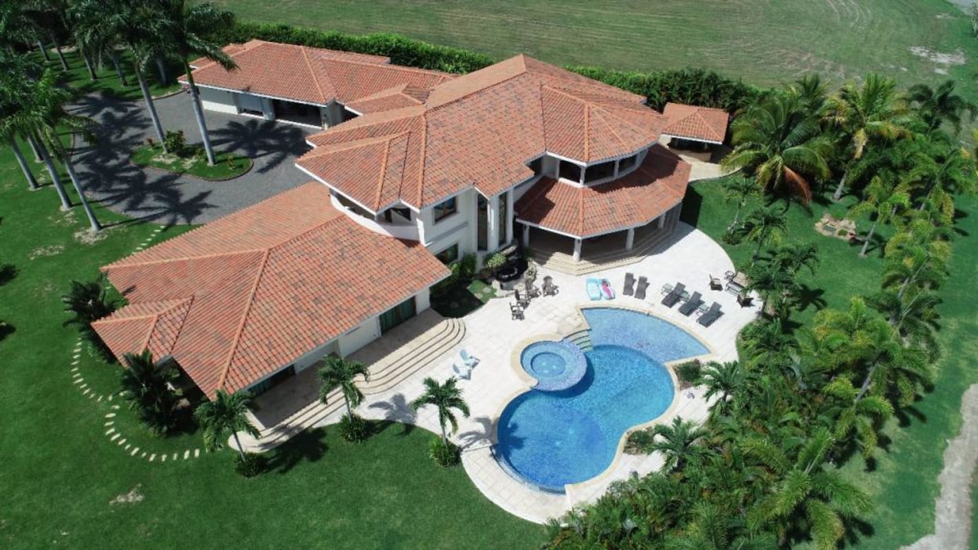 Aerial photo of expansive luxury estate with terracotta roofs, pool, gardens by ocean Buenaventura Panama