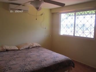 Cozy bedroom with windows, ceiling fan and closet overlooking garden Playa Malibu Panama