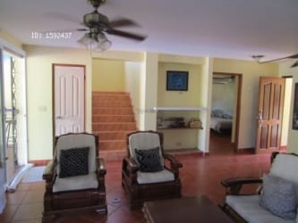 Traditional living room open to dining space ceiling fans and window Playa Malibu Panama