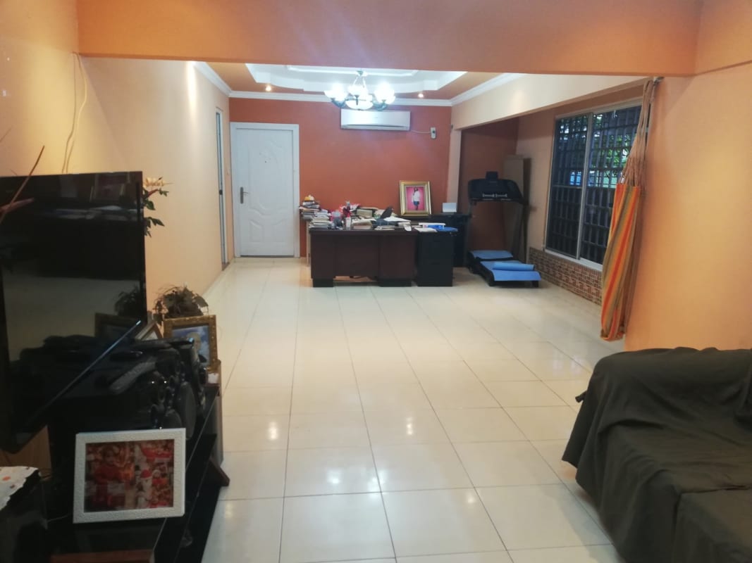 Living room with home office area, large window, TV, treadmill, Chanis Panama