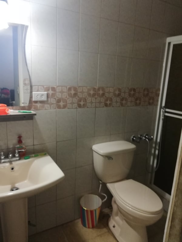 Bathroom with beige tiles, pedestal sink, mirror, walk-in shower, Chanis Panama