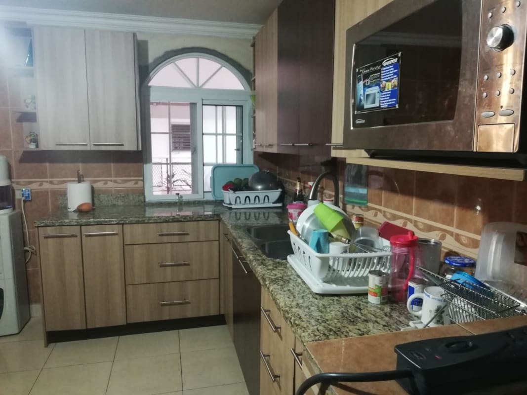 Kitchen with granite countertop, wood cabinets, arched window, Chanis Panama house