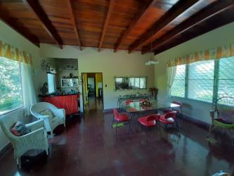 Lush garden with mature tropical trees, lawn and colorful plants surrounding estate in El Valle