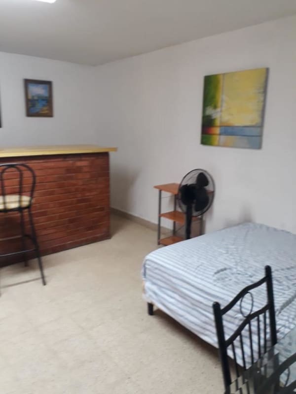 Studio apartment with exposed brick breakfast bar, striped bedding near Tumba Muerto Panama City