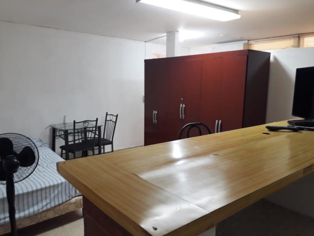 Cozy studio apartment with bed, wardrobe, dining area and TV at Villa de las Fuentes Panama City