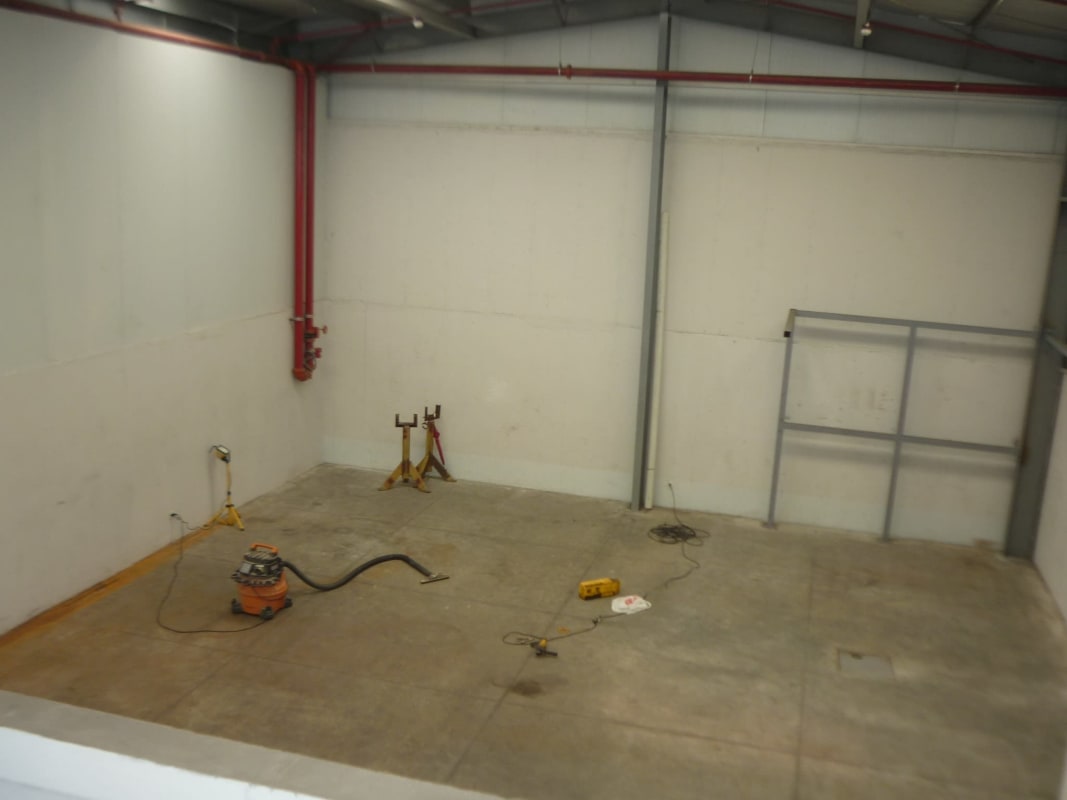 Spacious empty industrial warehouse with large windows and roller shutter door in Panama City