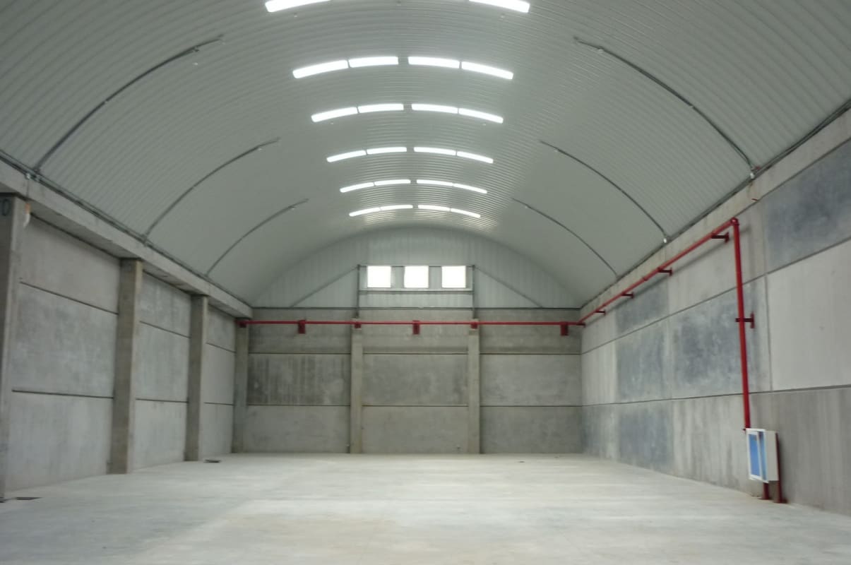 Spacious empty warehouse interior with concrete floors, skylights, fire sprinklers in Las Mañanitas Tocumen Panama