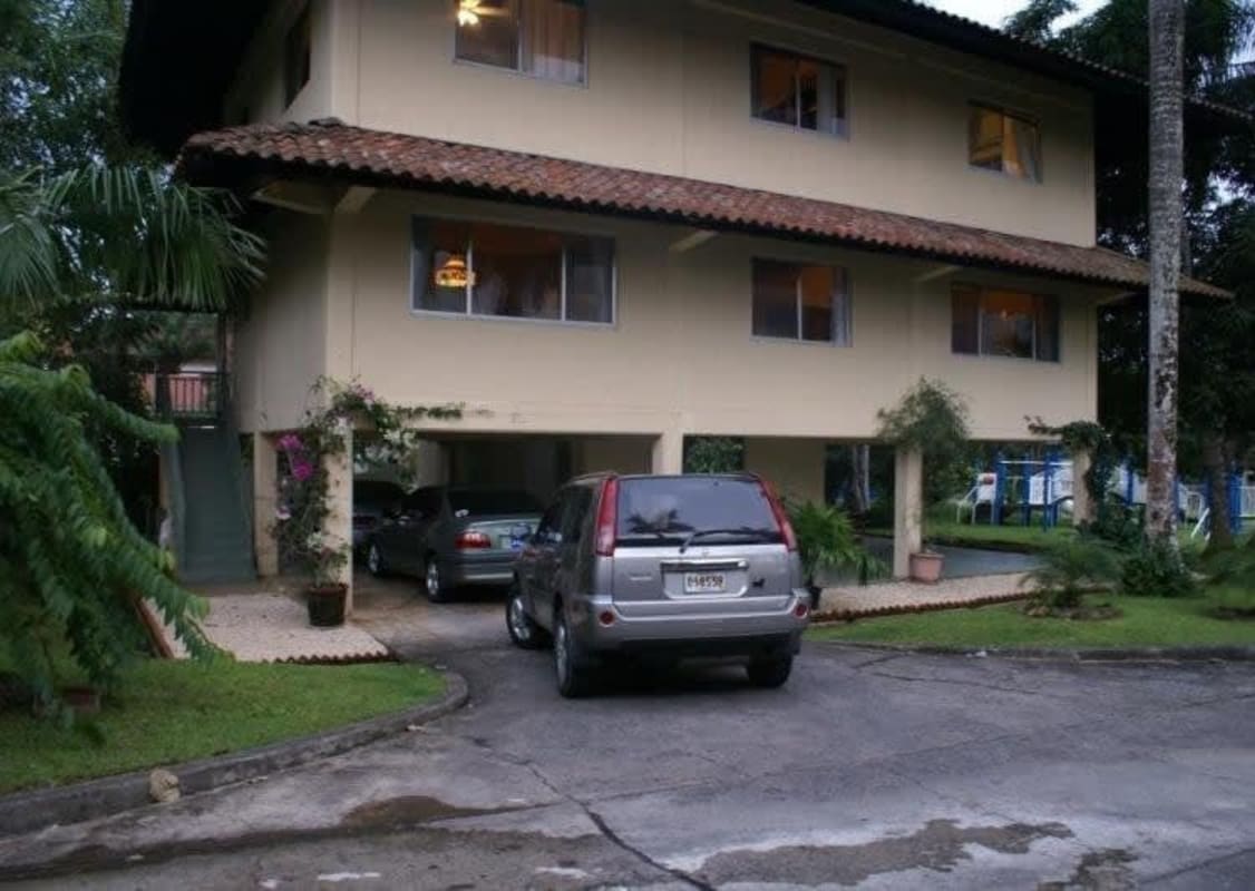 Traditional spacious living room with tile floors, chandelier, and large windows in Clayton house for sale Panama