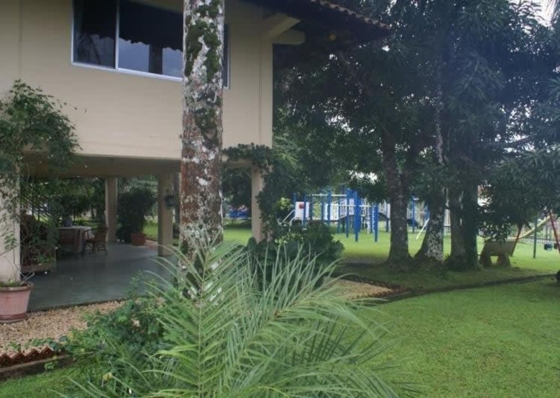 Family-friendly garden with children's swing set, open green lawn, tropical landscaping Clayton Panama