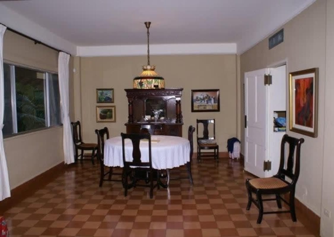 Traditional dining room with checkerboard floor, antique hutch, chandelier, Clayton house for sale Panama