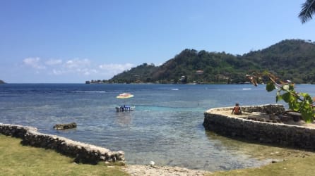 Bedroom with two beds, red curtains, AC unit, ceiling fan beachfront rental Isla Grande