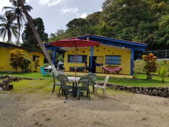 Eclectic kitchen with tiled island, refrigerator, microwave, window with blue curtain