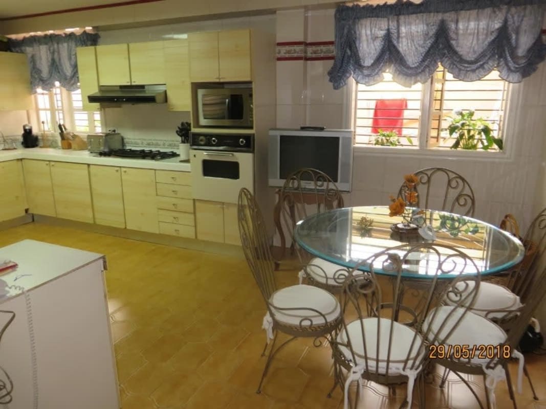 Kitchen with granite countertops, breakfast nook, modern appliances at La Alameda house in Panama City