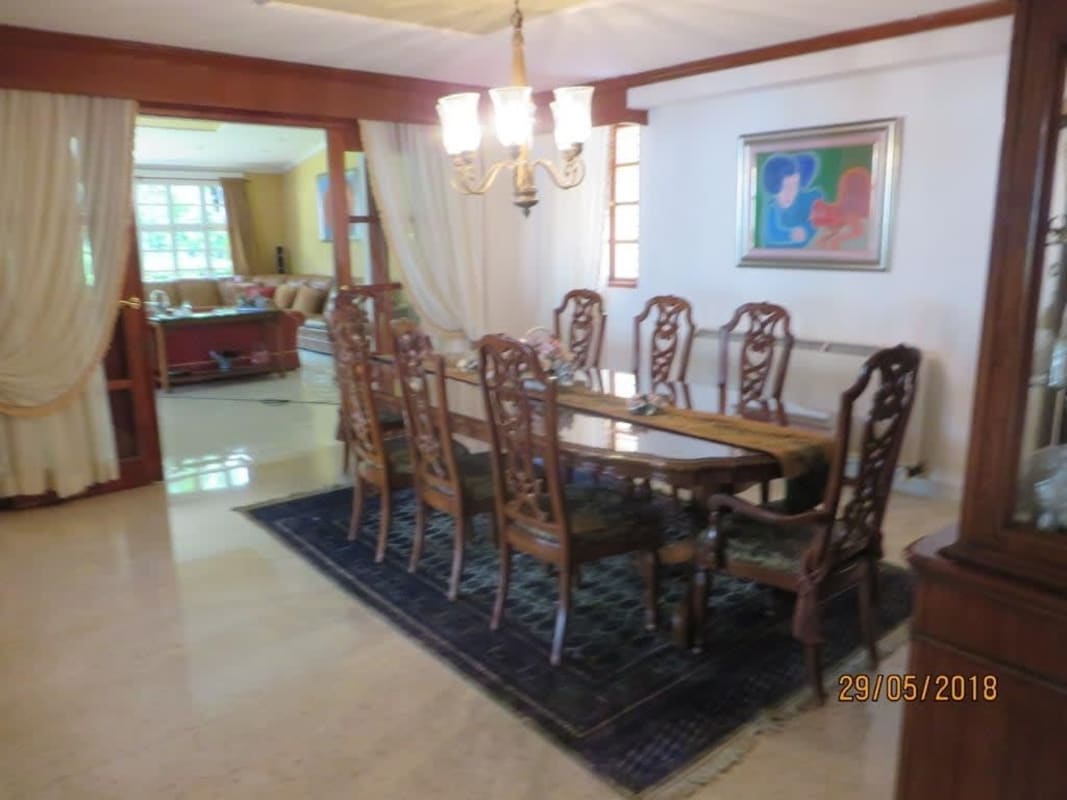 Elegant living room with marble floors, wood accents, spiral staircase, large windows in La Alameda house Panama City