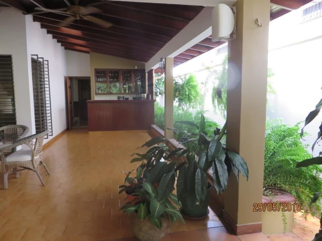 Outdoor private pool with sun deck, surrounded by tropical plants La Alameda Betania Panama City house