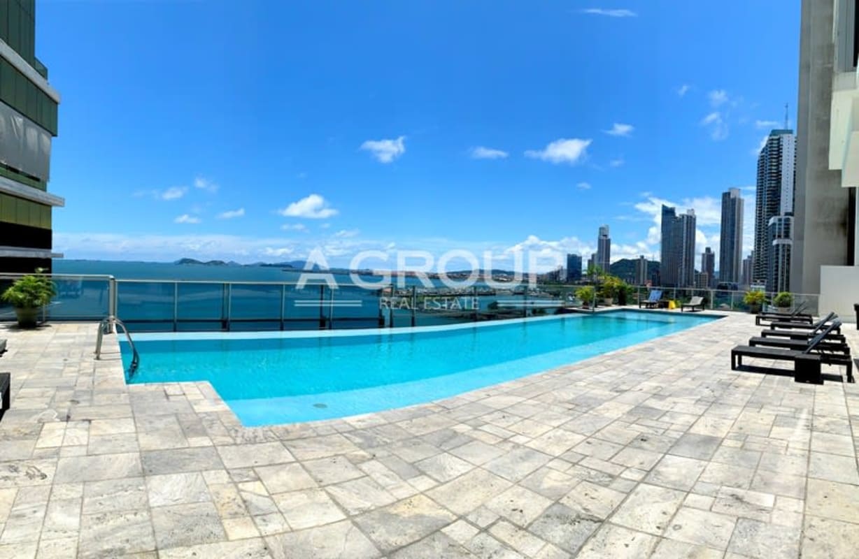 Modern bedroom with floor-to-ceiling windows and ocean skyline in PH Waters on the Bay Panama