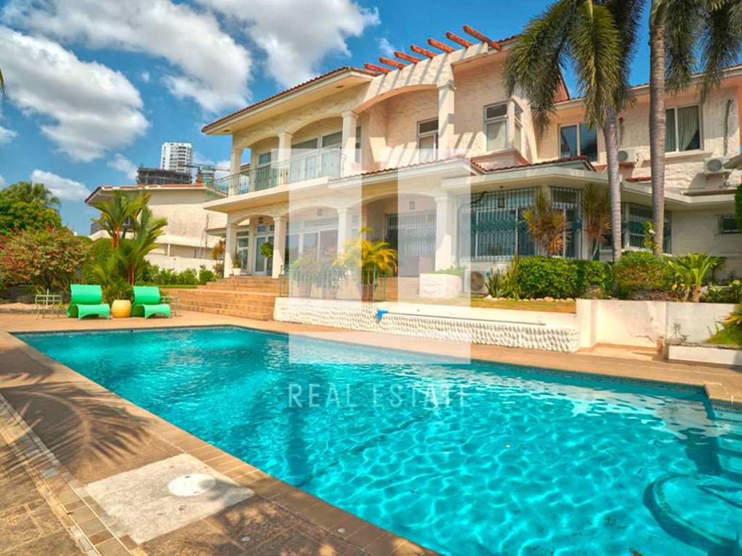 Modern gourmet kitchen with blue cabinetry, central island, professional gas range, view windows at Coco del Mar villa Panama