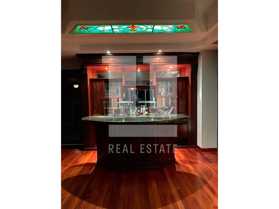 Traditional home bar with wood cabinetry granite counter stained glass ceiling in PH Bahia Esmeralda Marbella Panama
