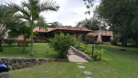 Single-story house with tile roof surrounded by lush garden Punta Barco Panama