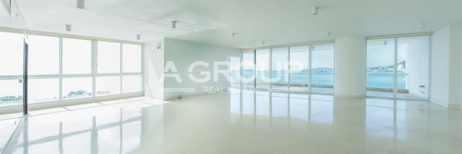 Large empty luxury apartment living room with floor-to-ceiling oceanfront windows at The Point Punta Paitilla Panama City