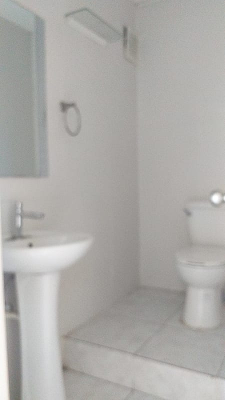 Minimalist tiled restroom with pedestal sink, mirror, ceramic tile PH Marbella Business Center