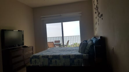 Furnished beachfront master bedroom with sliding doors and balcony at Buenaventura Puntarena Panama