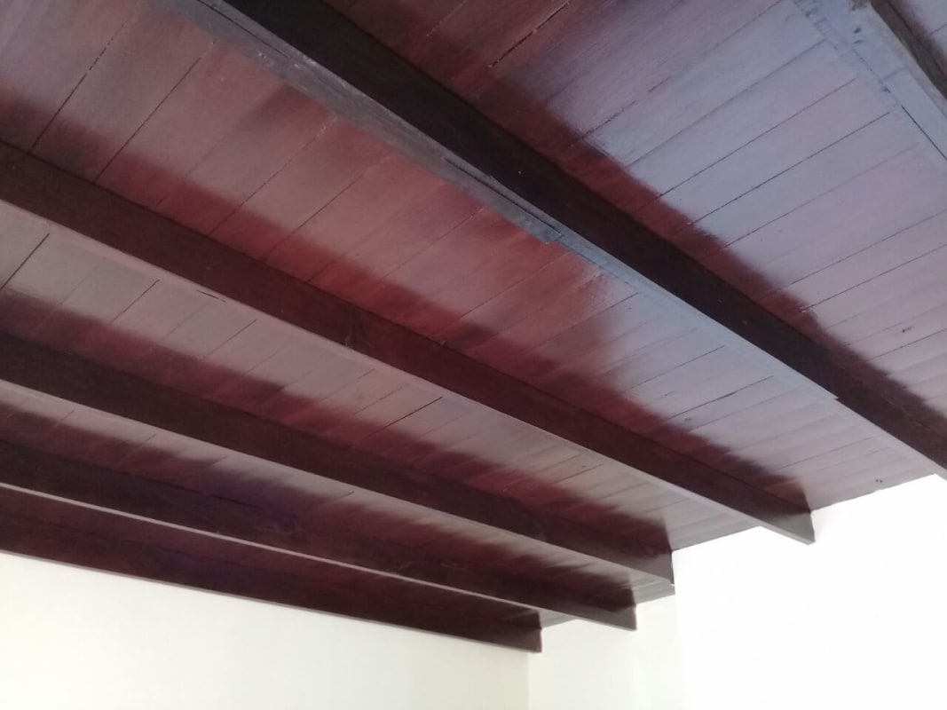 Interior ceiling with dark wood beams contrasting with white walls in Edificio 15 Panama